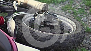 Close-up shot of motorcycle wheel on ground after an accident crash or fall . Slow motion