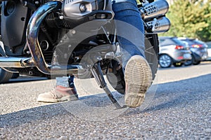 Close-up shot of motorcyclist positioning the kickstand