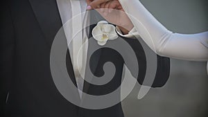 Close-up shot of the newlywed couple is tenderly holding hands. The groom is softly kissing the bride hand.