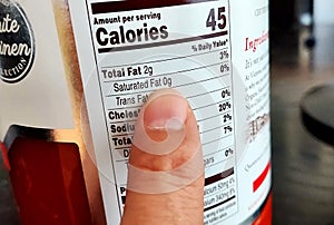 Close-up shot of a Nutrition label with finger pointing to the Total Saturated Fats