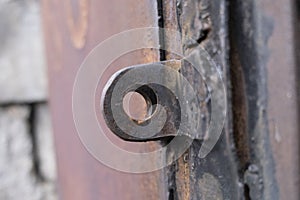 A close up shot of an old rusted key on a metal door keyhole