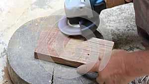 Close up shot  of old worker hands carpenter equals polishes wooden board with a random orbit sander in the workshop, sanding vint