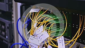 Close-up shot of an optical fiber connector board with yellow and green cables. Stock footage. Interior details of