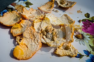 A close up shot of orange peel and seeds in a white plate. Orange peel also contains good amounts of provitamin A, folate,