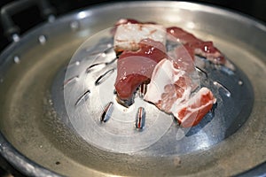 Close-up shot of the pan for Thai Barbecue or Moo Kra Ta with some pork.