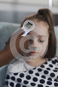 Close up shot of pediatric hospital nurse measuring sick little girl body temperature