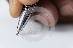 Close up shot of a pen nib writing on paper with a human hand shot in macro mode