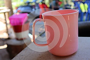 Close-up shot of a pink plastic drinking glass placed on a selectable focus table.