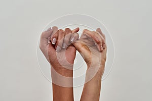 Close up shot of pinky swear. Promise hand gesture isolated over light background