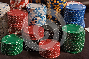 Close-up shot of a poker chips stacks standing on a table in casino.
