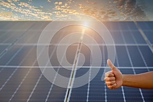 Close-up shot poses positive gesture on solar panel photovoltaic On the roof of the house and with a thumbs up or like Money