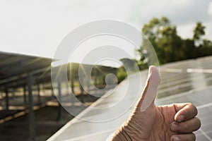 Close-up shot poses positive gesture on solar panel photovoltaic On the roof of the house and with a thumbs up or like Money