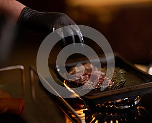 Close-up shot, a professional chef expertly prepares a delicious steak using modern cooking techniques, showcasing