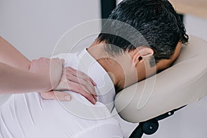 close-up shot of professional masseuse doing seated massage photo