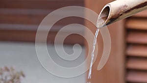 Close up shot of purification fountain with bamboo and stone basin