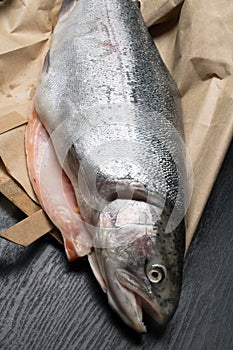Close up shot of raw fresh rainbow trout on a black background on paper bag Preparations for cooking