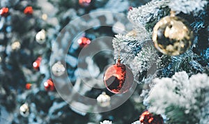 Close-up shot Red bauble and gold bauble hanging from a decorated Christmas tree. Retro filter effect. Christmas tree and