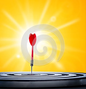 Close up shot red dart arrow on center of dartboard concept for photo