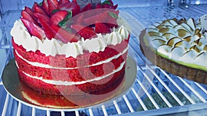 close-up shot of refrigerator with a strawberry cake and whipped cream