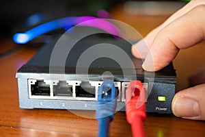 Close-up shot of a router - a red cable is connected next to the blue Ethernet cable. Concept of cabling, internet network,