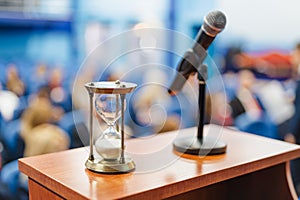 Close-up shot of an sand clock next to a microphone