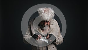 Close-up shot of a senior, gray-haired male counting his money