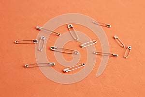 Close up shot of sewing pins on an orange colored background