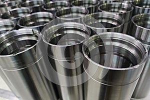 A close-up shot of shiny steel aerospace cnc turned tubes in a batch with selective focus and background blur