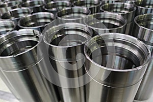 A close-up shot of shiny steel aerospace cnc turned tubes in a batch with selective focus and background blur photo