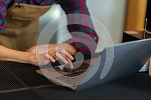 Close-up shot of shopkeeper\'s hands typing on laptop computer. because they are replying to customer chats who come to order