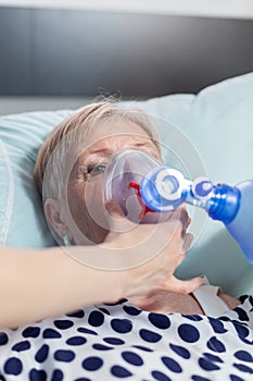 Close up shot of sick senior woman inhale and exhale