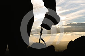 Close up shot silhouette young man photographer hiking and holding camera standing on the mountain peak