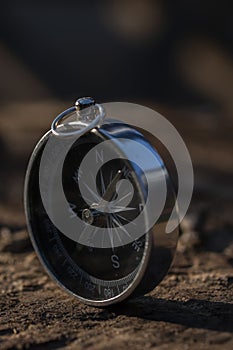 Close up shot of a silver metal compass always pointing it's needle towards North