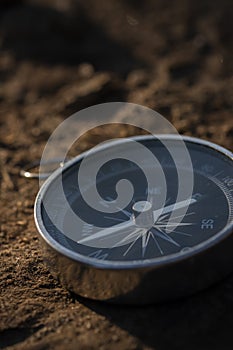 Close up shot of a silver metal compass always pointing it's needle towards North