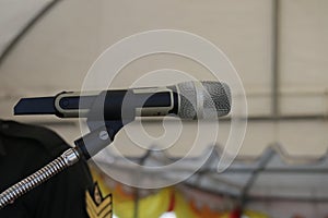 Close-up shot of a silver microphone set up on select focus event concept stage.