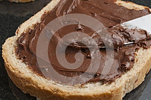 Close-up shot of a slice of cereal bread with chocolate hazelnut cream spread