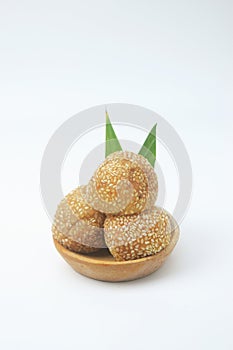 A close up shot of a snack that has a golden round shape is often called Onde Onde photo