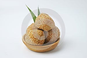 A close up shot of a snack that has a golden round shape is often called Onde Onde photo