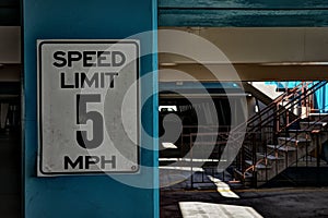 Close-up shot of a speed limit sign affixed to the column in a parting lot