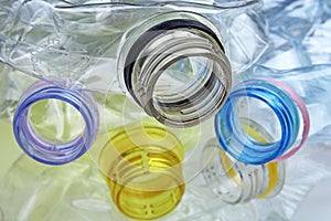 Close-up shot of stack of recyclable plastic bottles on white background.