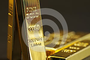 Close up shot of stacked 999.9 pure gold bar ingot on a black background