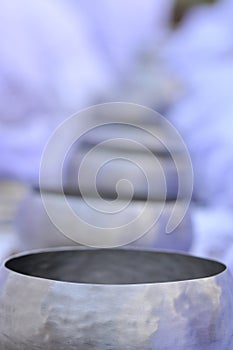 Close-up shot of stainless steel alms bowl arranged on the floor In a Buddhist ordination ceremony in a temple in India