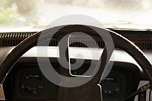 Close up shot of a steering wheel and dash in an old car