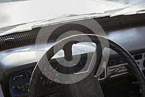 Close up shot of a steering wheel and dash in an old car