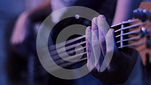 Close up shot of strings and guitarist hands playing guitar over black - shallow DOF with focus on hands