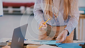 Close-up shot of successful businesswoman standing behind office table on business team meeting, giving directions.