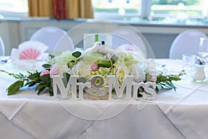 Close-up shot of a table decoration with flowers and Mr & Mrs sign