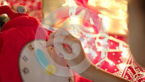 Close up shot of teen girl hands translating toy clock hands to Christmas midnight