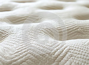 A close-up shot of the texture and pattern on a mattress, highlighting its softness and comfort for sleeping. The