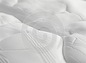 A close-up shot of the texture and pattern on a mattress, highlighting its softness and comfort for sleeping. The